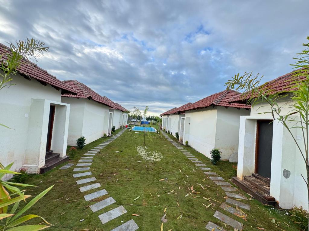 拉米斯瓦拉姆Road House Resort的一排白色房子，房子之间有草坪