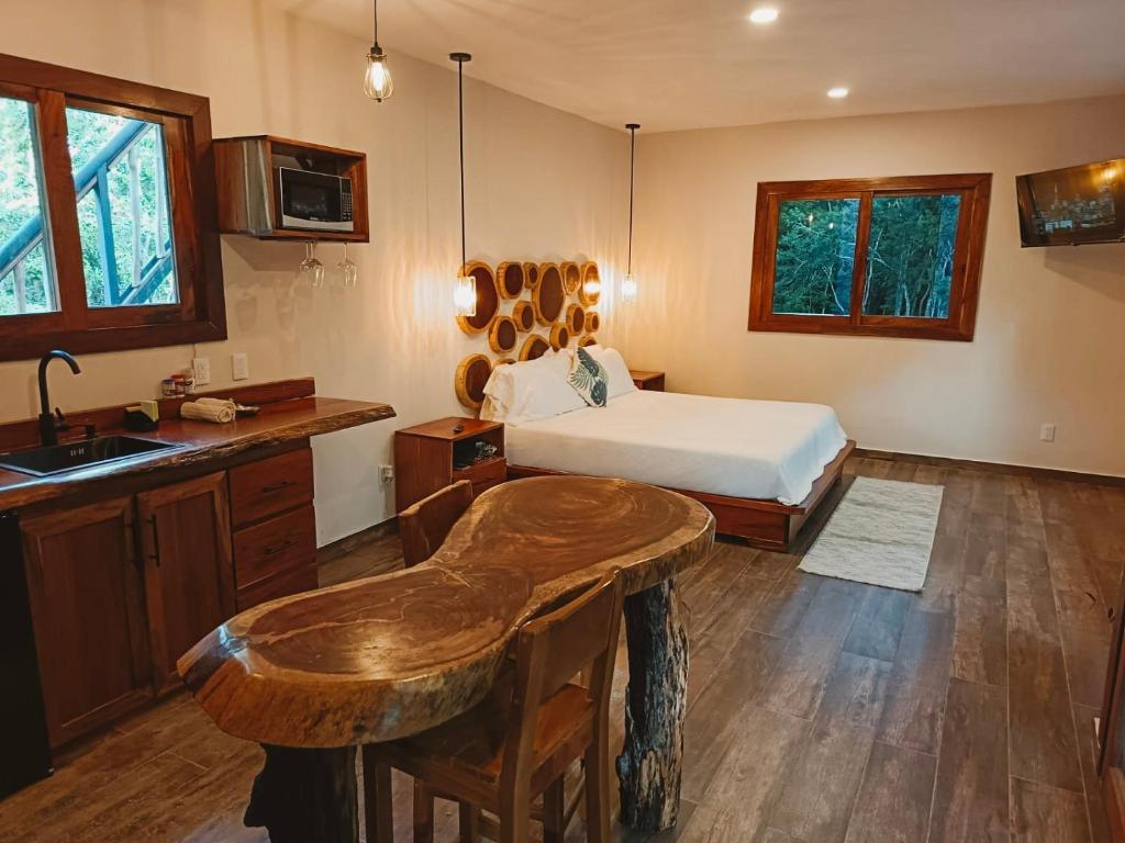 ein Schlafzimmer mit Bett und eine Küche mit Spüle in der Unterkunft Hotel Cabañas Aldea Maya in Xpujil