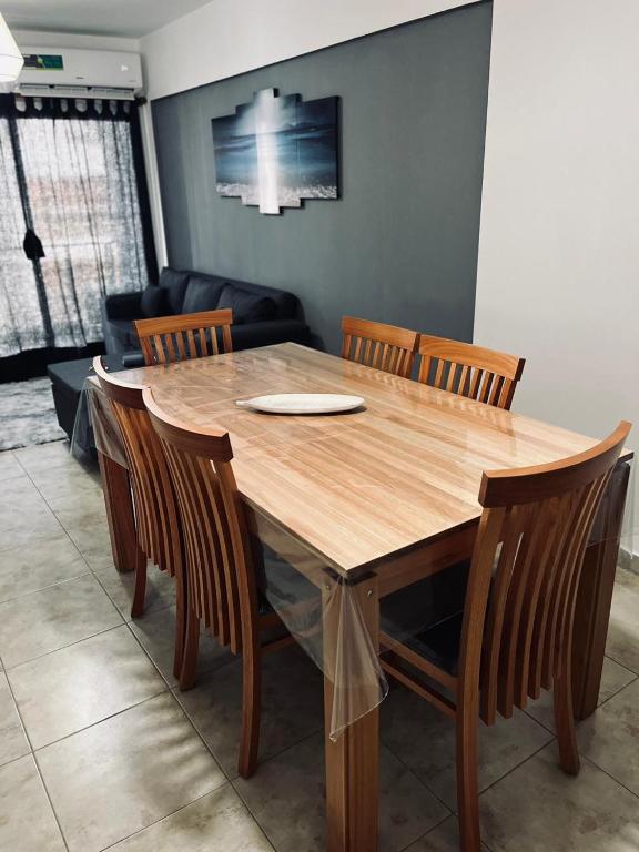 een houten tafel en stoelen in de woonkamer bij Antherina in San Luis