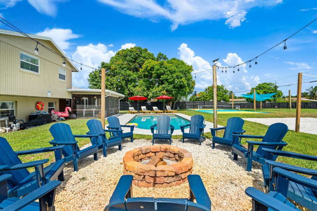 a patio with chairs and a fire pit next to a pool at Your own 5BR Private Oasis! wPrivate PoolPickleball in West Palm Beach
