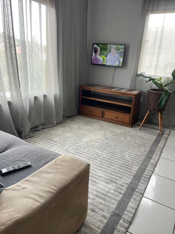 ein Wohnzimmer mit einem Flachbildfernseher an der Wand in der Unterkunft Lugar pra relaxar...Perto de tudo .. in Búzios