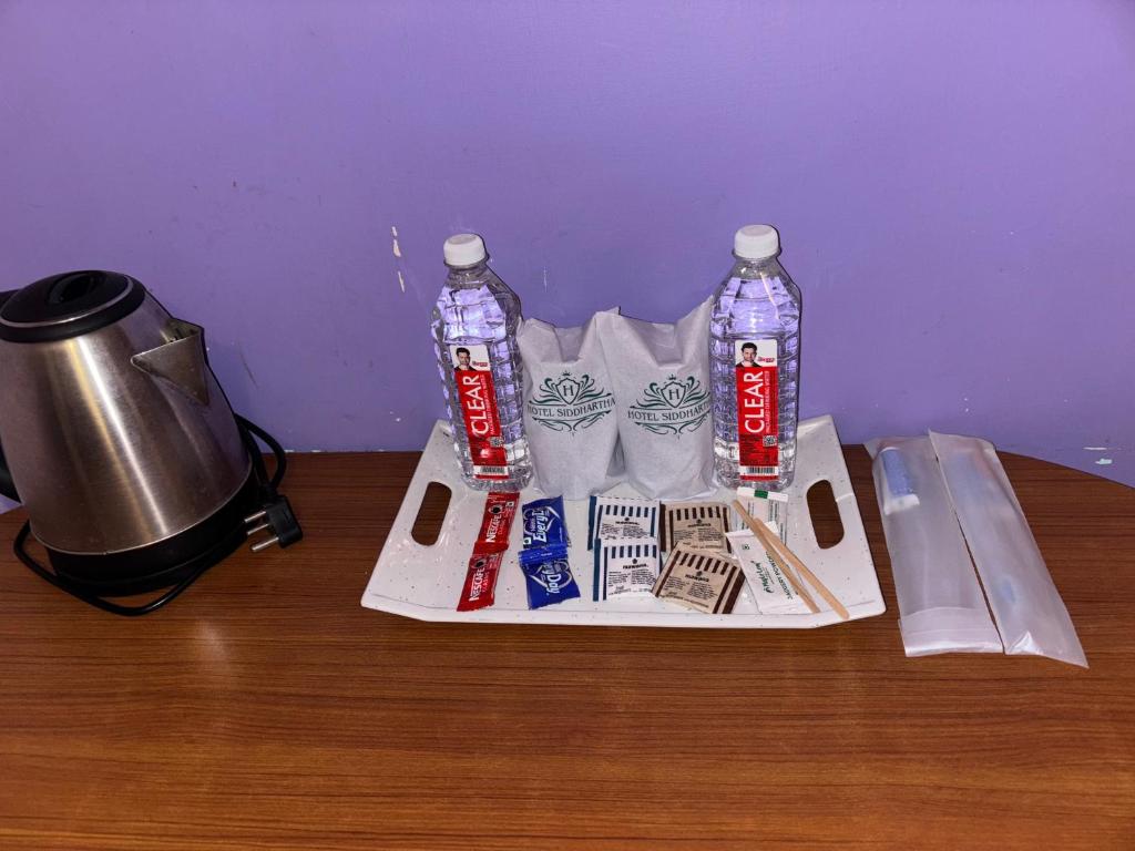uma mesa com duas garrafas de bebidas em uma bandeja em Hotel Siddhartha em Bodh Gaya