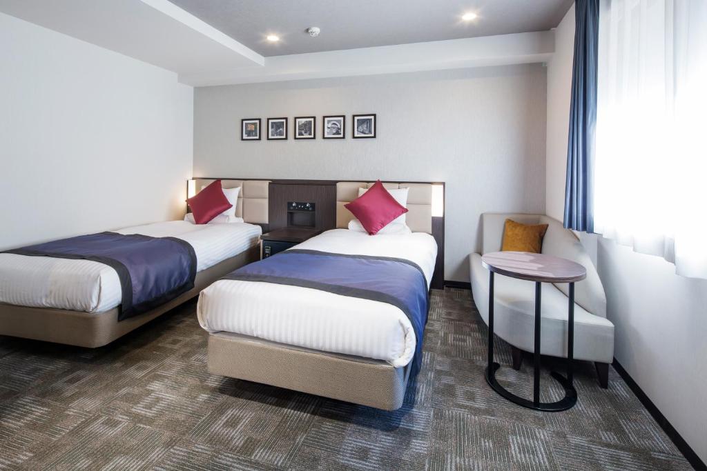 Postel nebo postele na pokoji v ubytování HOTEL MYSTAYS Kanda