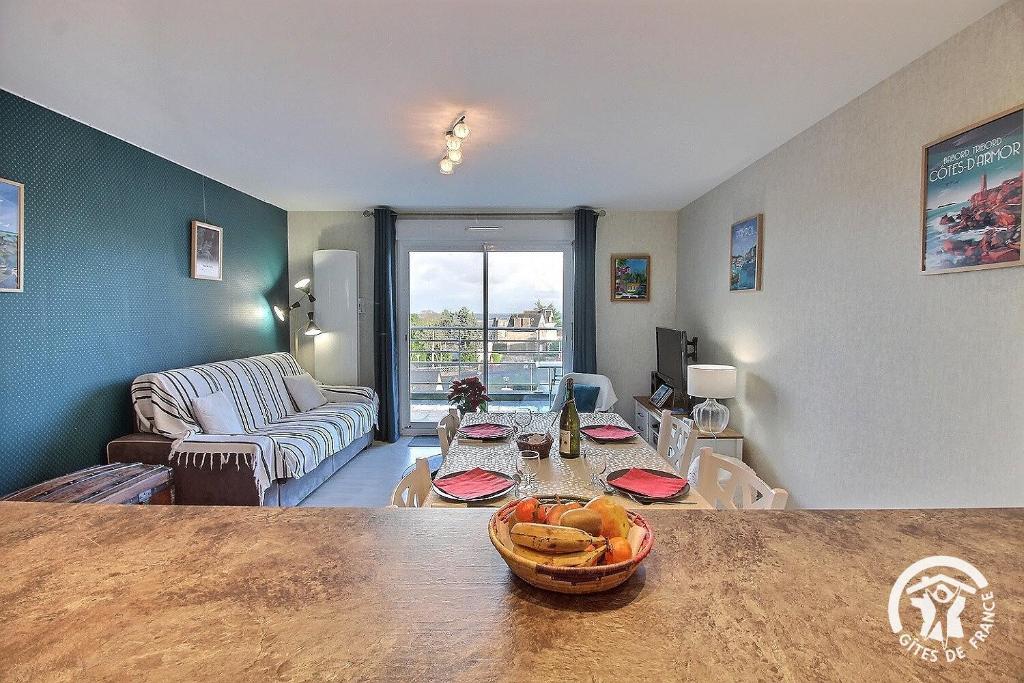 a living room with a table with a bowl of fruit at Le balcon de la baie in Paimpol