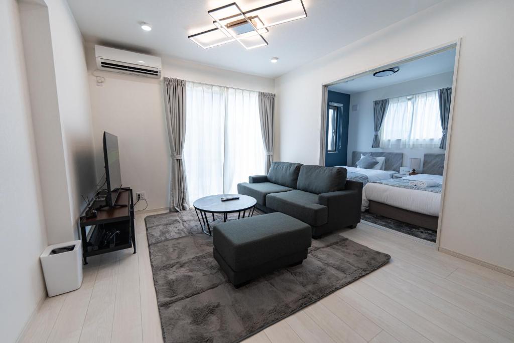 a living room with a couch and a bed at Villa Nuunu in Miyako-jima