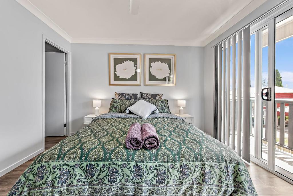 BundambaModern New Townhouse in Booval的一间卧室配有一张带绿床罩的床