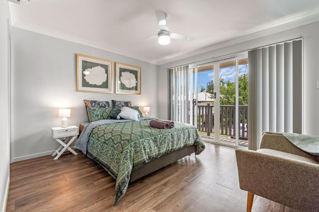 a bedroom with a bed and a large window at Modern New Townhouse in Booval in Bundamba
