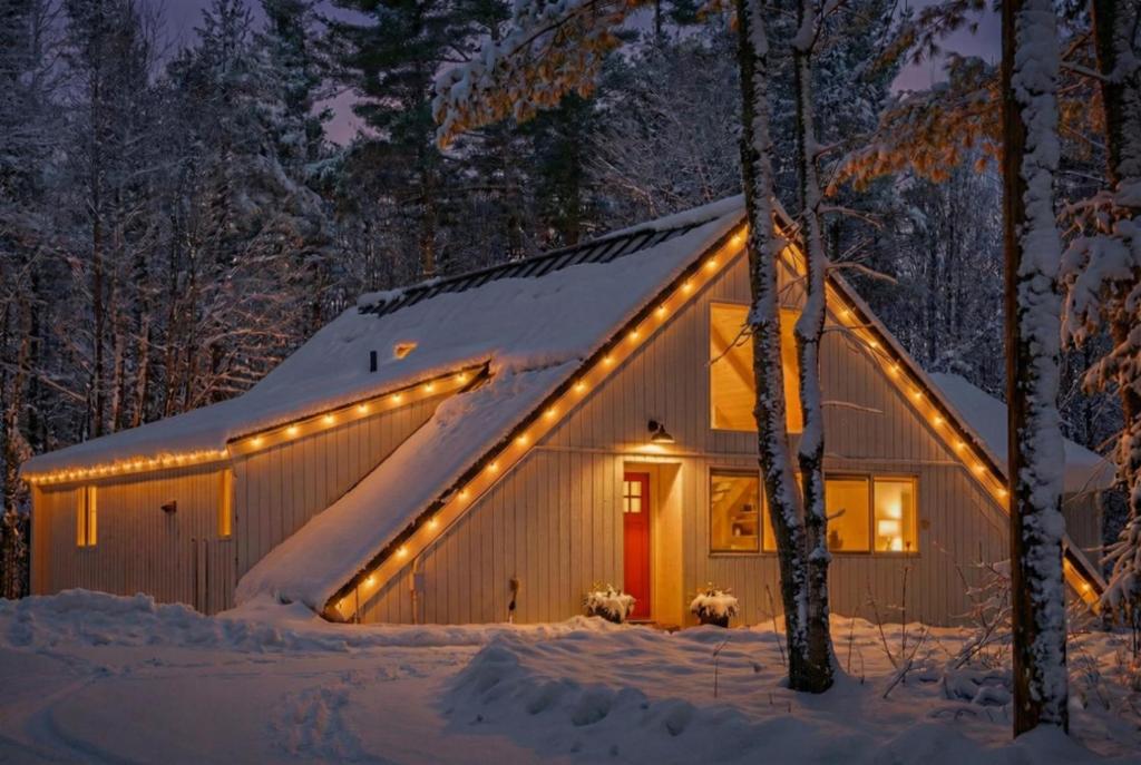 a barn with lights on it in the snow at Stratton Ski Haus, Green Mountain Wellness Retreat, Hot Tub & Barrel Sauna in Jamaica