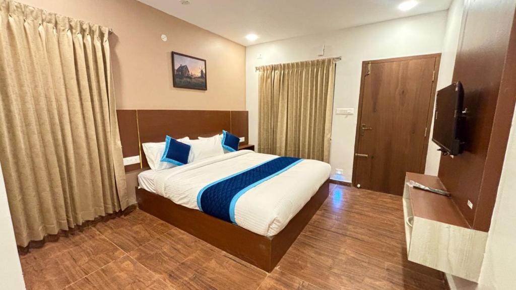 a hotel room with a bed and a television at Hotel Park Land in Kodaikānāl