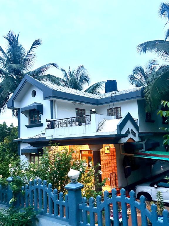 a house with a blue fence in front of it at Sujata Homestay 2 in Ponda
