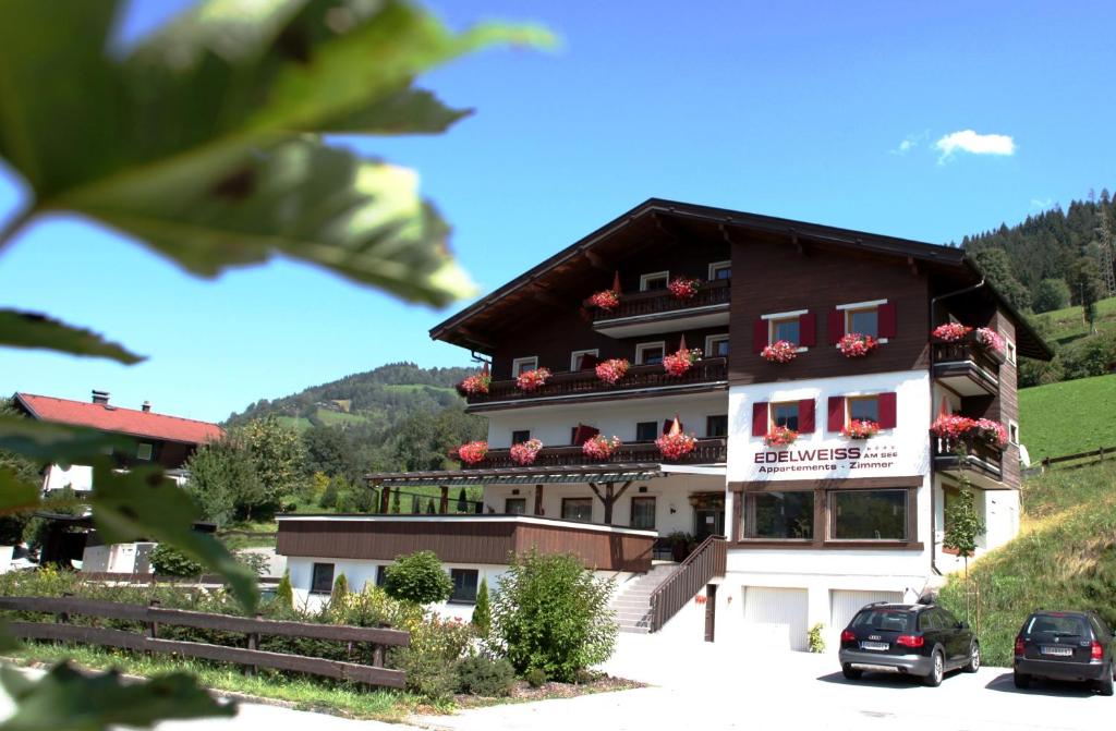 a large building with red flowers on the balconies at Edelweiss am See in Zell am See