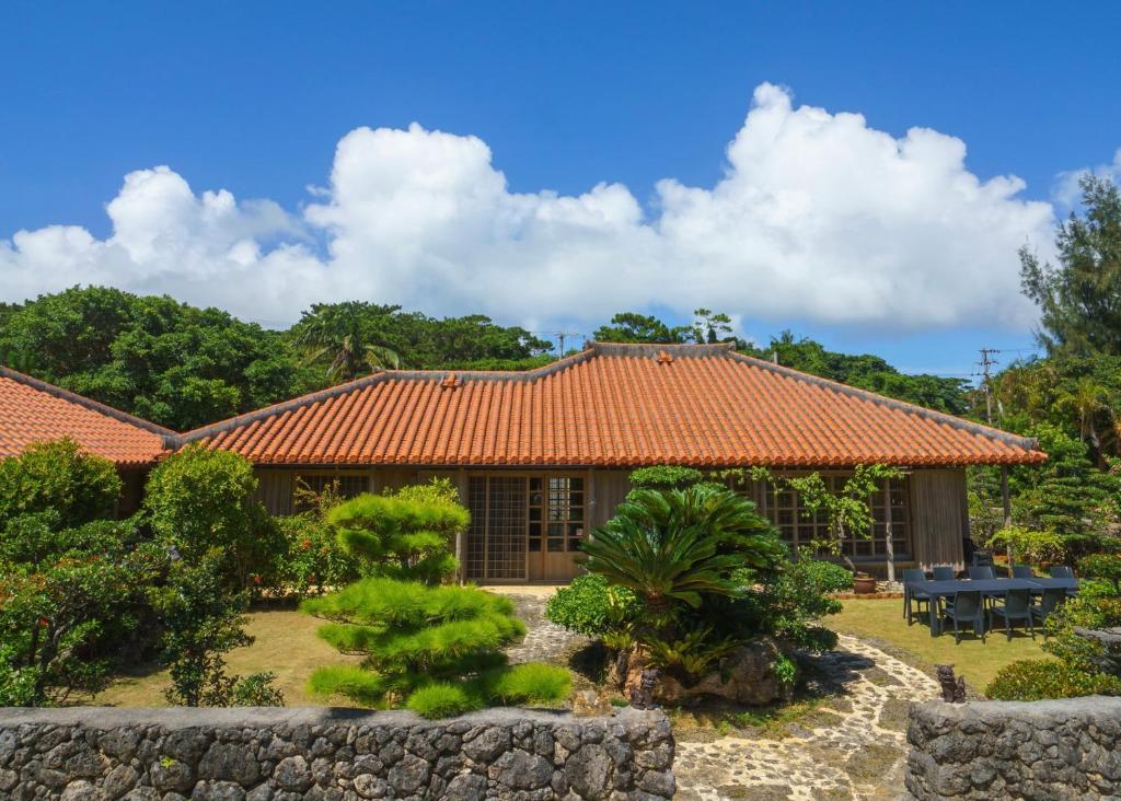 a house with an orange tile roof at かたあきの里 in Miyako Island