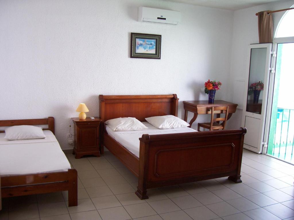 Postel nebo postele na pokoji v ubytování Hôtel Le Nathania