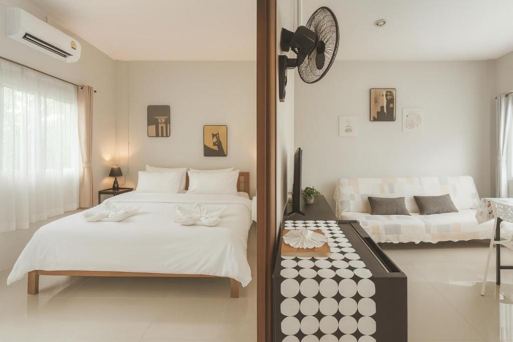 um quarto com duas camas e um relógio na parede em Yada House s&h em Nai Yang Beach