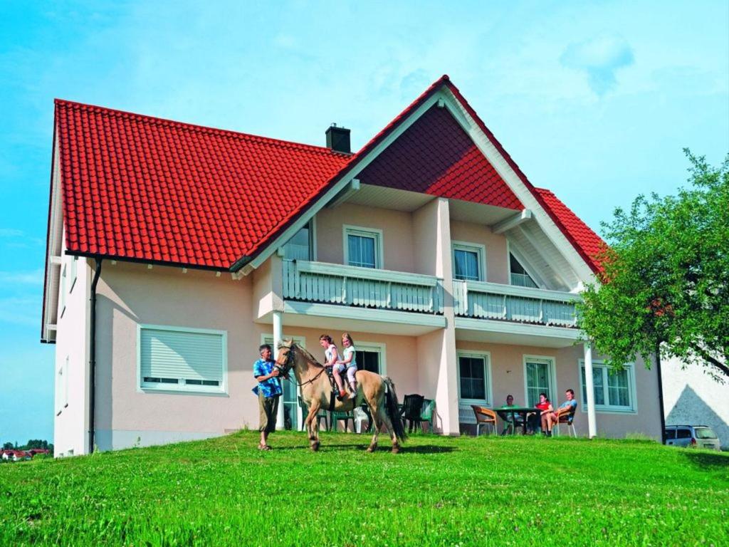 un grupo de personas montando caballos delante de una casa en Ferienwohnungen Lindlhof, en Riedenburg