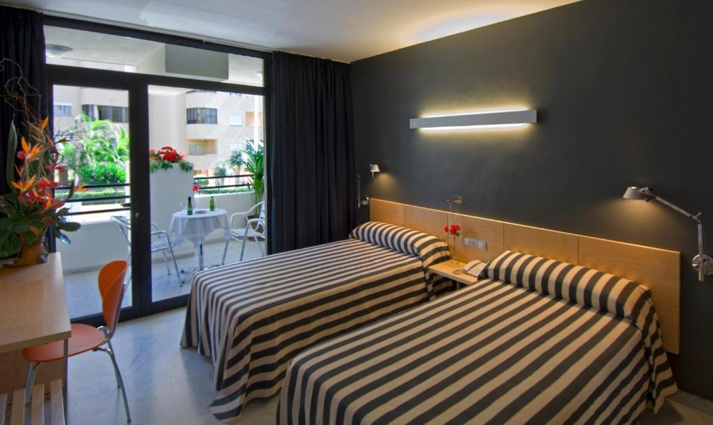 a hotel room with two beds and a balcony at Hotel Nautico in Santa Cruz de Tenerife