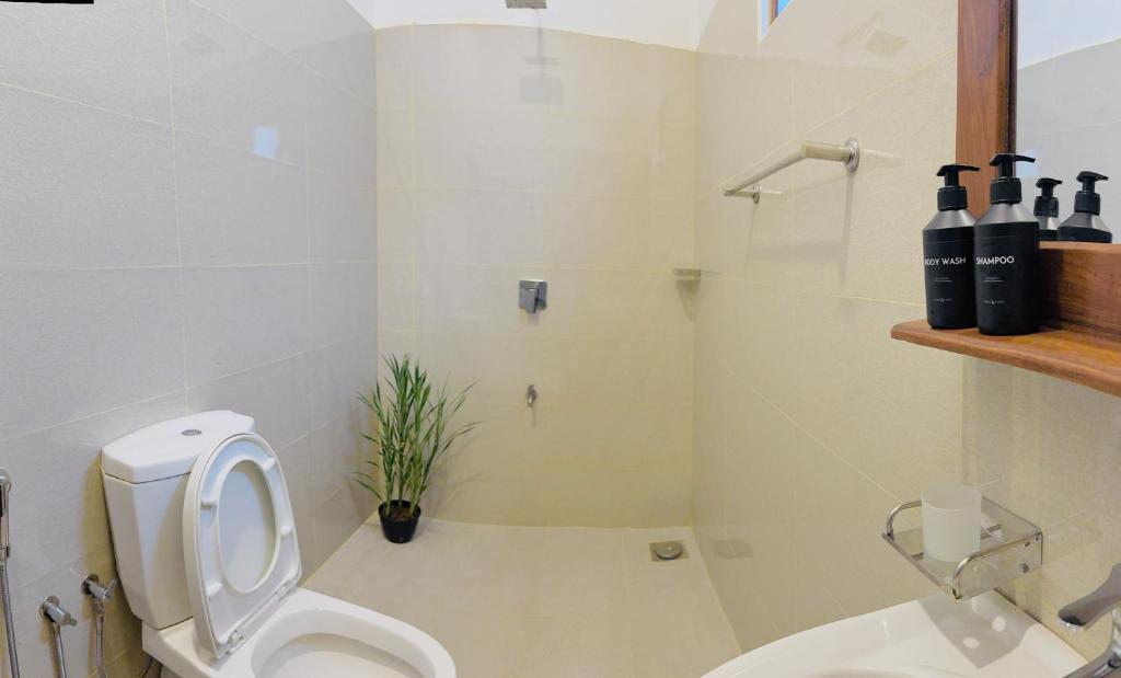 un bagno bianco con un water e un lavandino di Eden Villa - Ahangama ad Ahangama