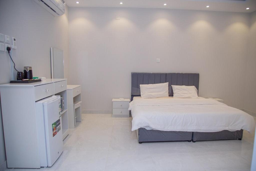 1 dormitorio blanco con 1 cama y vestidor en ديلوكس فخامة مكة, en An Nikāshah