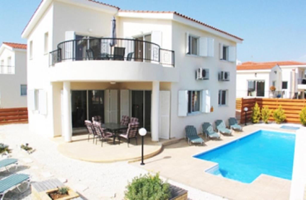 a villa with a swimming pool and a house at Villa Vista in Paphos