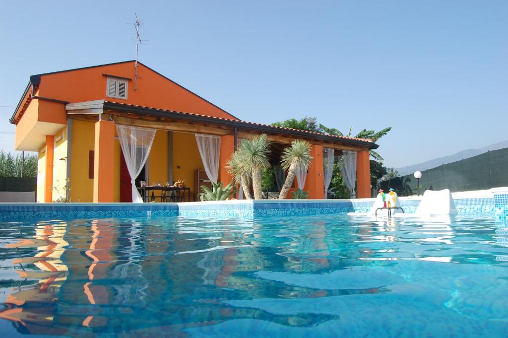 uma piscina em frente a uma casa em OMBRA E CAFFE' em Mascali