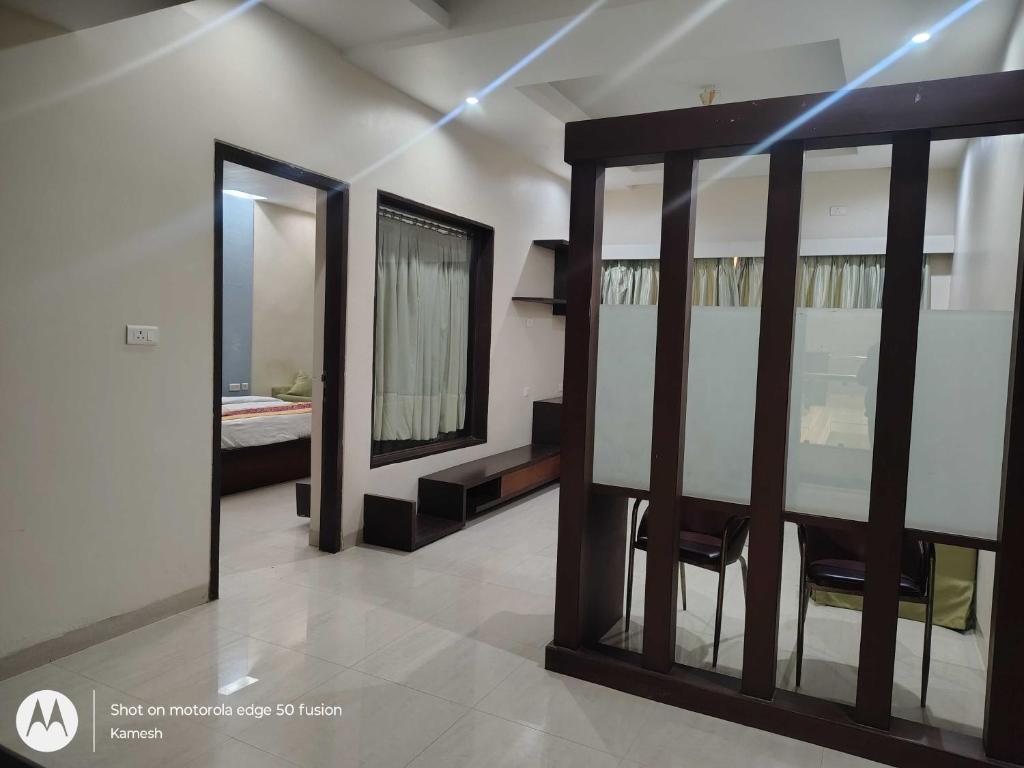 um quarto com um espelho e uma mesa e cadeiras em Townhouse Kakinada Nagamalli Thota Junction em Kākināda