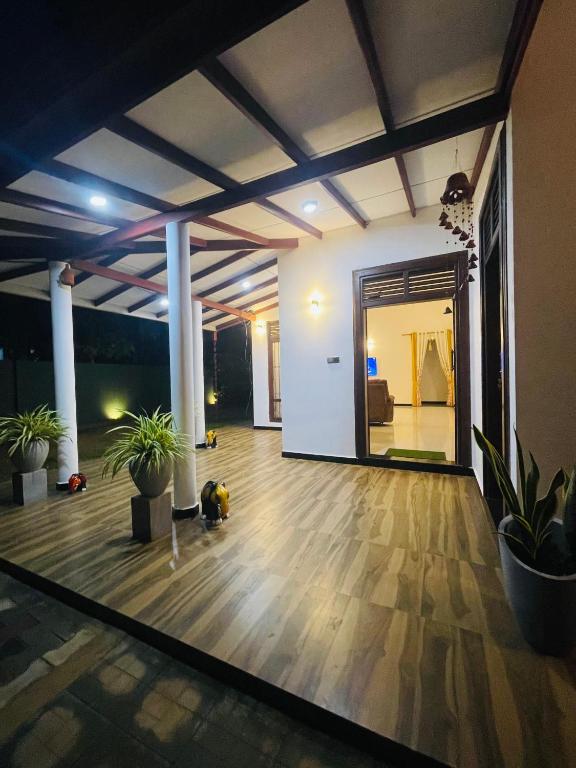 a living room with a wooden floor and a large mirror at Coco Villa Yala in Tissamaharama