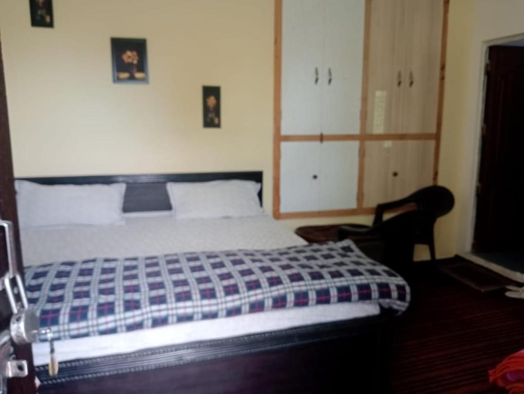 Hawālbāghjai maa kasardevi homestay的卧室里有一张床和一把椅子