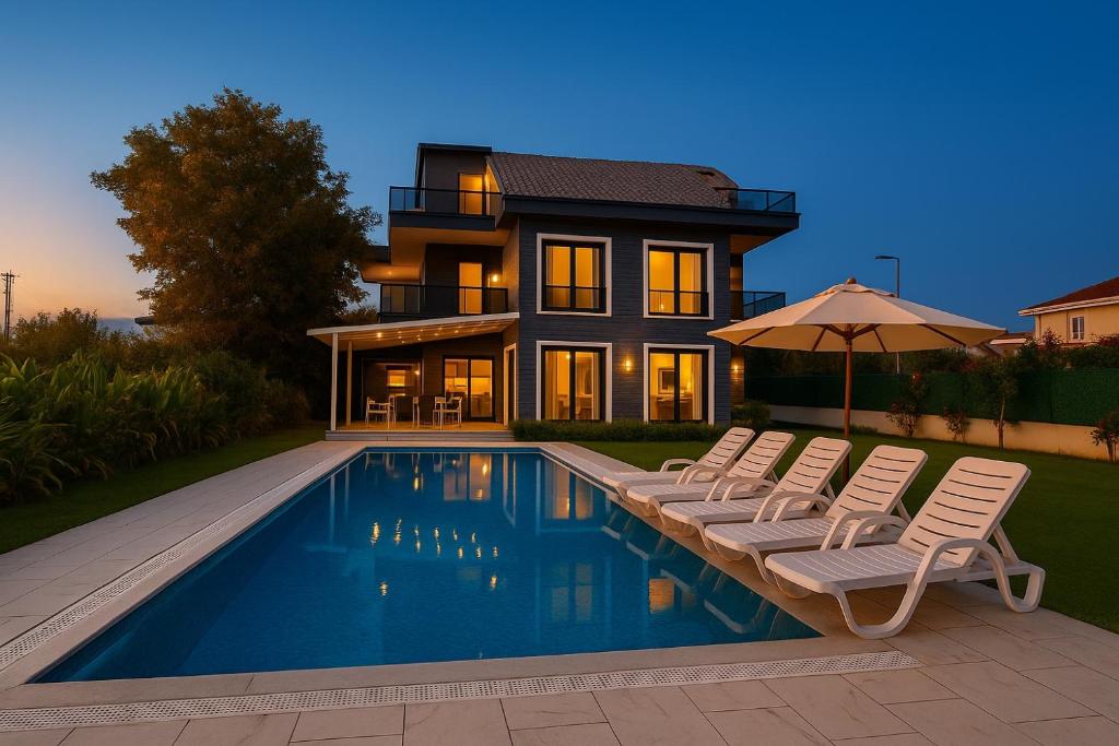 una casa con piscina di fronte a una casa di ŞAHNAZ VİLLA Suits a Belek