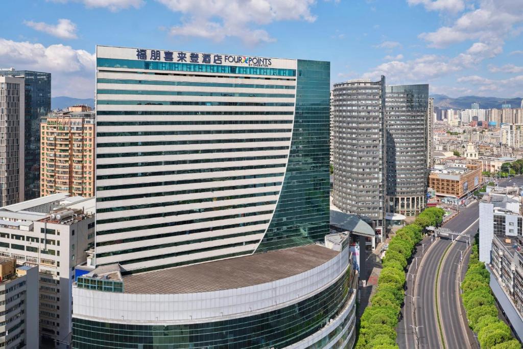 a tall building in the middle of a city at Four Points by Sheraton Kunming, Downtown in Kunming