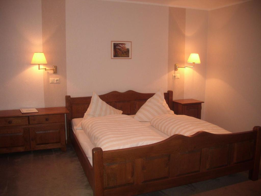 a bedroom with a bed and two night stands and lights at Landhotel Pingel in Sundern