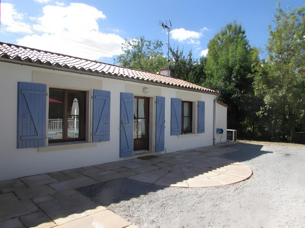 莫雷勒斯Gîte Nénuphar - Gîtes Au Bas Marais的一座白色的小建筑,上面有蓝色的门