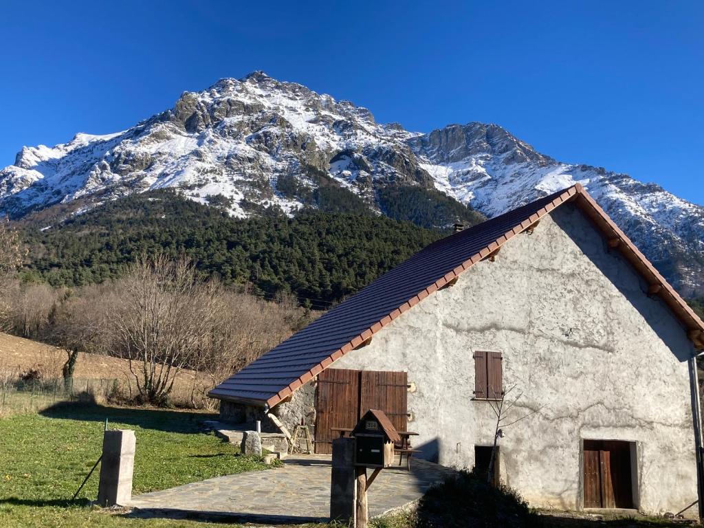 Les CostesLe hameau du Maissubert的背景中可以看到一座白雪皑皑的山峰，以及一栋建筑。