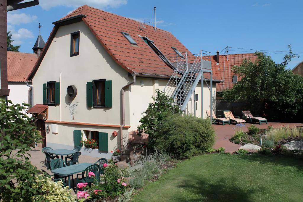 ein Haus mit einem Tisch und Stühlen im Hof in der Unterkunft Gîte Sylvaner sur la route des vins in Kintzheim