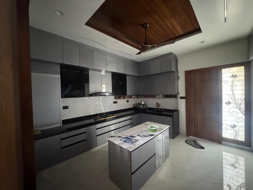 a kitchen with stainless steel appliances and a wooden ceiling at NTH Villa in Udaipur