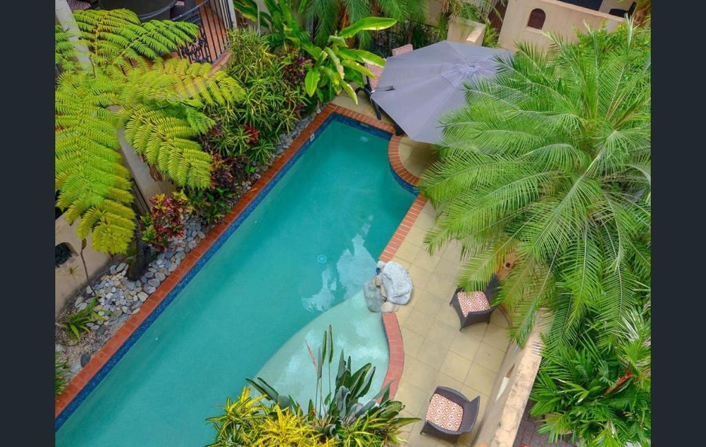 2BR Ground-Floor Gem, Walk to Everything, 2 Pools في ميناء دوغلاس: اطلالة علوية على مسبح مع مظلة