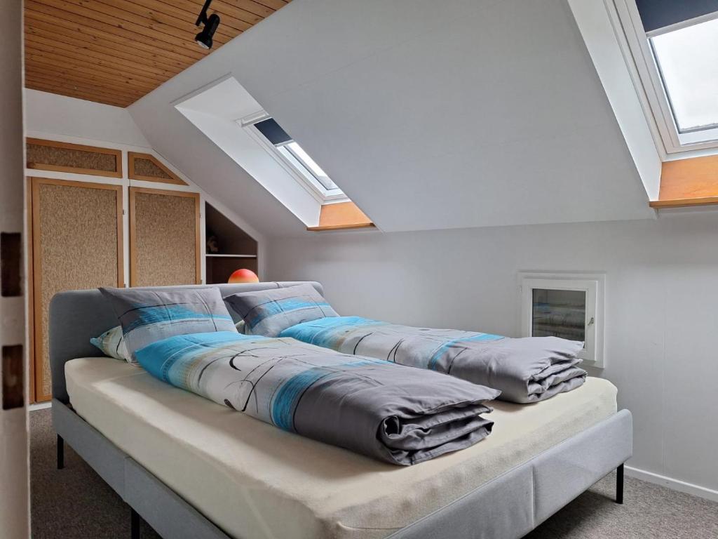 drei Kissen auf einem Sofa in einem Zimmer mit Dachfenstern in der Unterkunft Dachwohnung in Niederuzwil