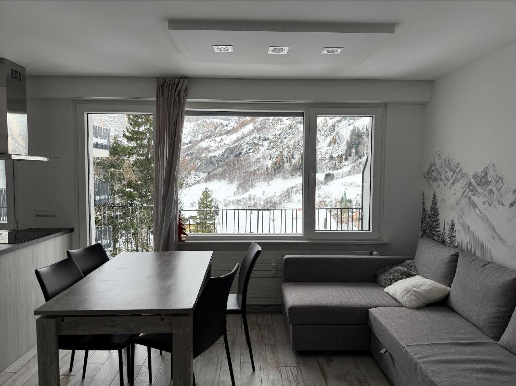 a living room with a couch and a table at Haus Flaminia 15 - Best view studio / Free parking in Leukerbad