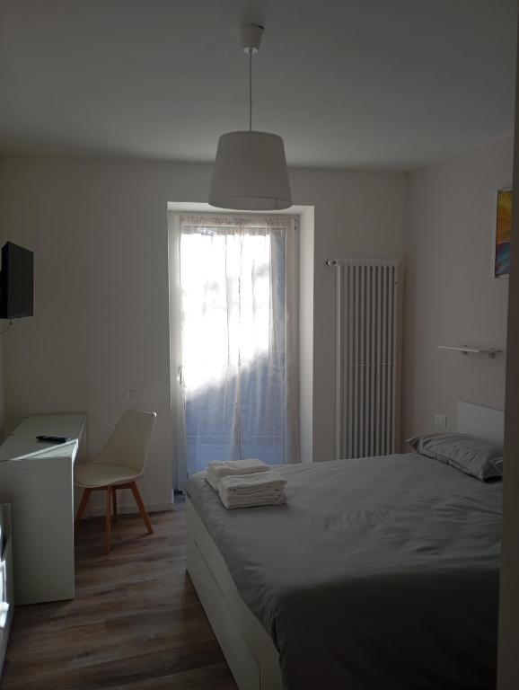 a bedroom with a bed and a chair and a window at B&B La casa sul Vela in Trento