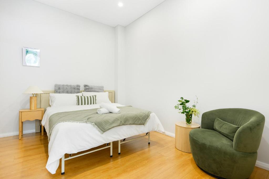 Un dormitorio con una cama y una silla verde. en Modern Riverwood Home with Parking & Easy Access, en Riverwood
