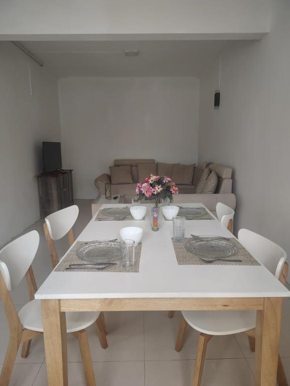 a dining room table with white chairs and a couch at Private Haven Escape in Pereybere