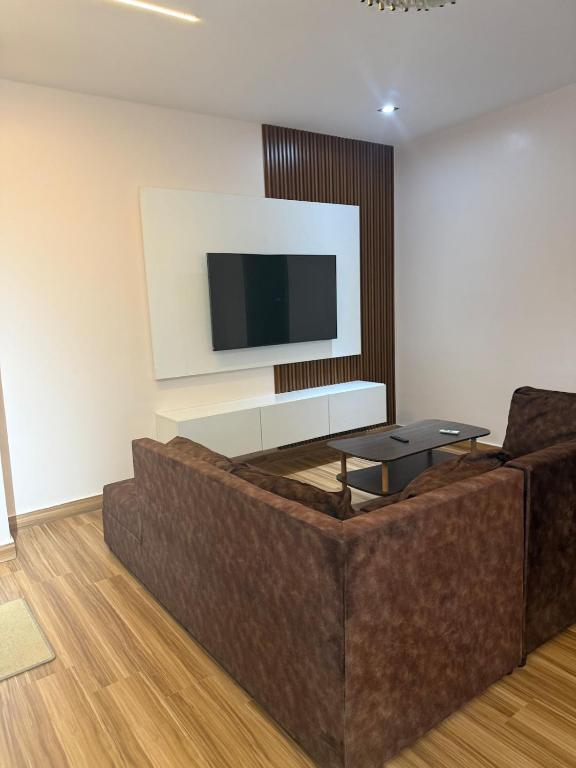 un soggiorno con divano e TV a schermo piatto di Decent One Bedroom Apartment at Tantra Hills a Tantra Hill