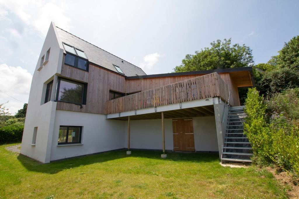 a house with a wooden facade and a staircase at Jolie maison neuve PMR au port de l'Aberwrac'h in Landéda