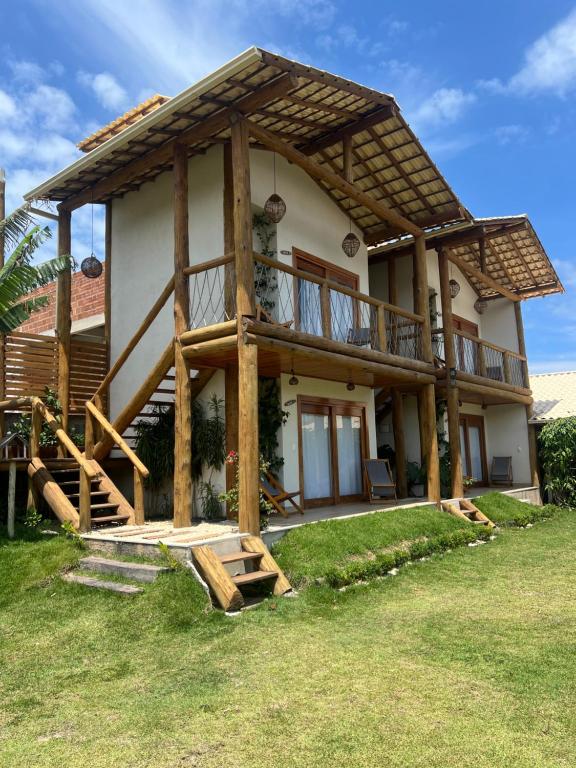 a house with a porch and a balcony at Bangalo Aconchegante - Praia Dulé ES - Suite 1 in Guarapari