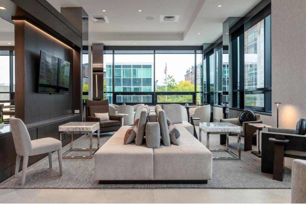 a lobby with a waiting area with chairs and tables at AC Hotel by Marriott Burlington in Burlington