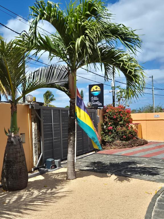 una palma davanti a un edificio con una bandiera di Jolie Villa Santa avec piscine a Pointe-aux-Piments
