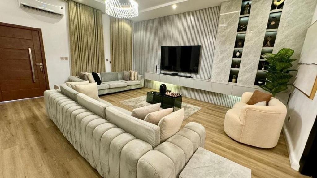una gran sala de estar con sofás y TV de pantalla plana. en XQUSITE APARTMENTs, en Lekki