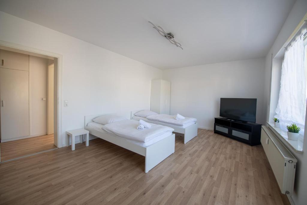 a white living room with a couch and a tv at WundP Living Wohnung mit Terrasse Parkplatz in Biberbach