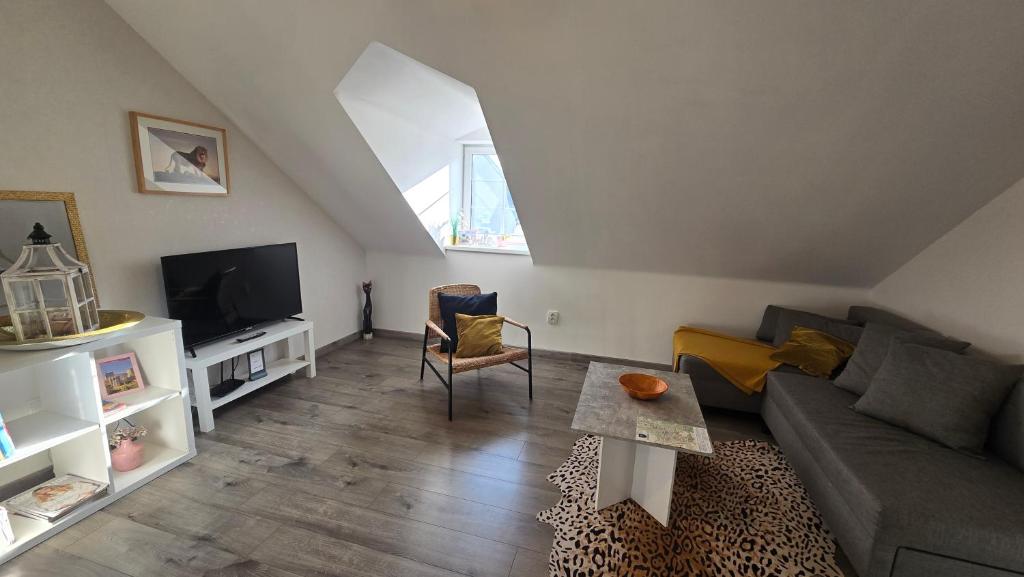 ein Wohnzimmer mit Sofa und Fernseher in der Unterkunft Apartmán - Café Princ pod Hradem WiFi, KLIMA in Šternberk