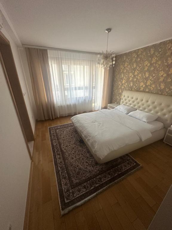 une chambre avec un grand lit blanc et un tapis dans l'établissement Ilidza Suite, à Sarajevo