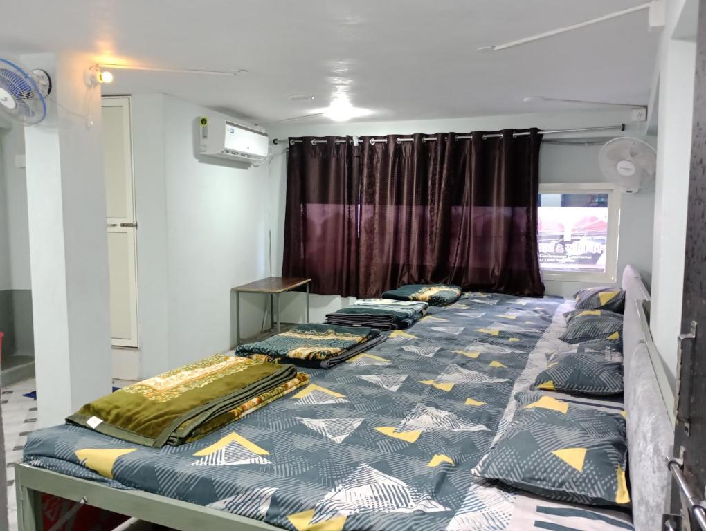 a room with a bed with pillows on it at Modern Guest House in Ujjain
